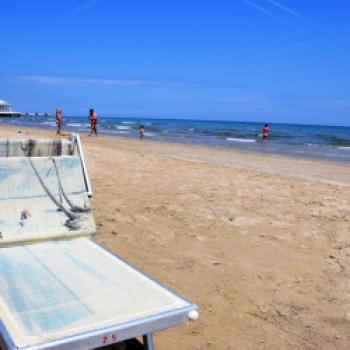 Das sommerliche Badevergnügen an der Adria: Am kilometerlangen Sandstrand reihen sich die Liegestühle und Sonnenschirme der Strandbäder eng an eng aneinander- (c) Gabi Vögele